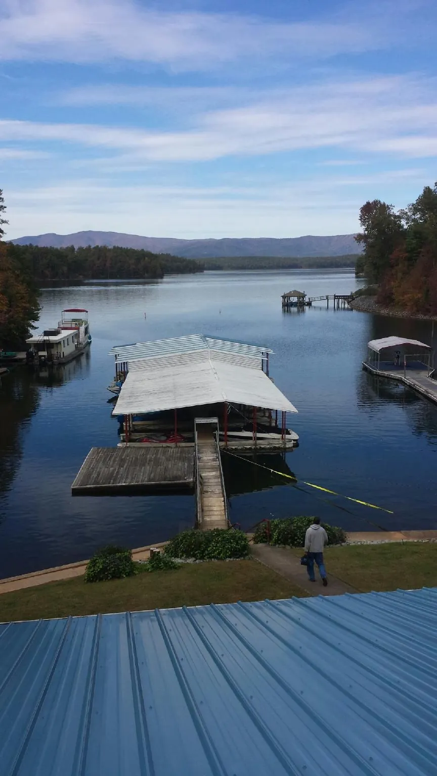 View across a lake from a newly installed blue metal roof in North Salem