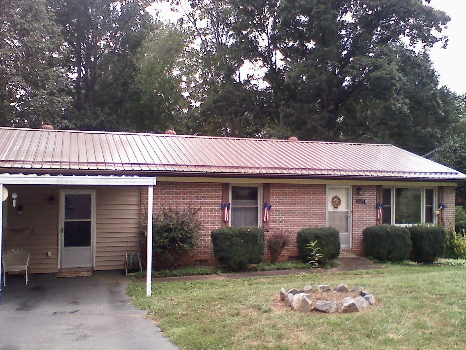 Bronze metal roof and carport on a brick ranch home — Roof Repair work by our crew in North Salem